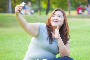 Pretty fat female takes travel selfie at the park